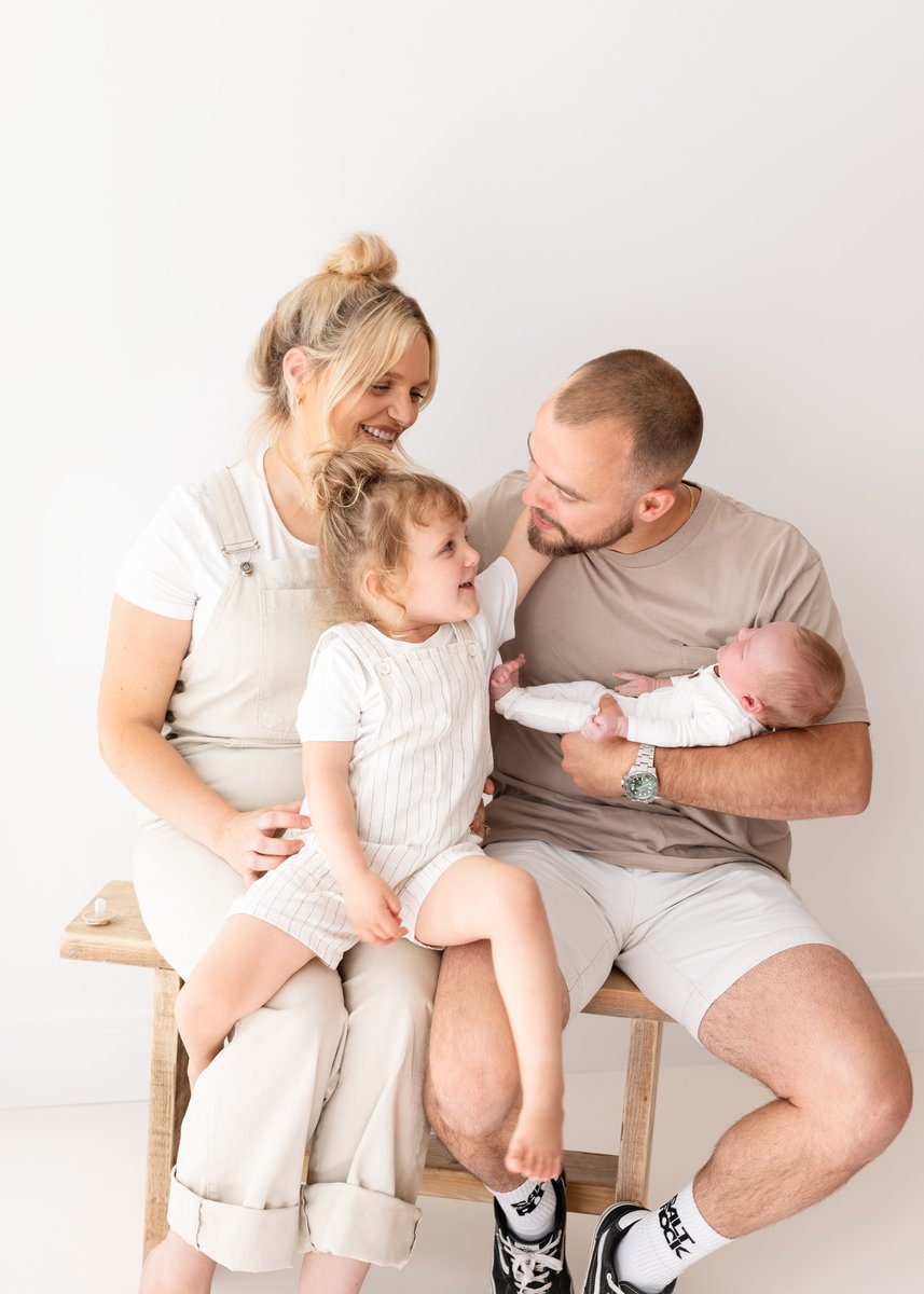 Family photoshoot with mum, dad, newborn baby and sibling in neutral colours