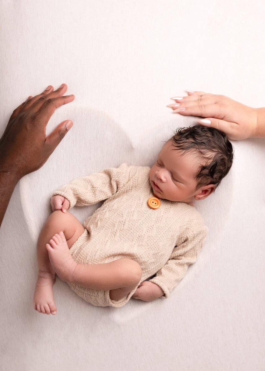 Newborn posed photographs with parents hands included